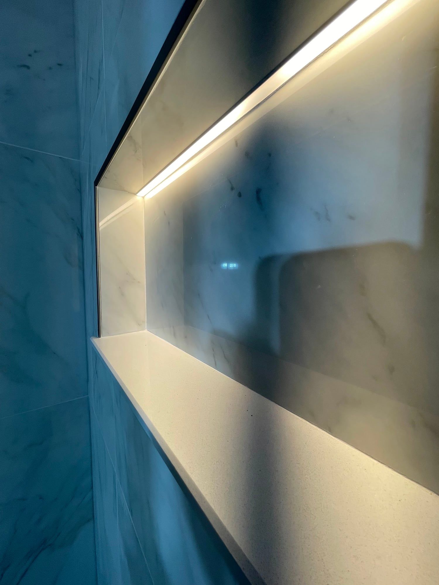 LED-lit shower niche set into marble-look tile