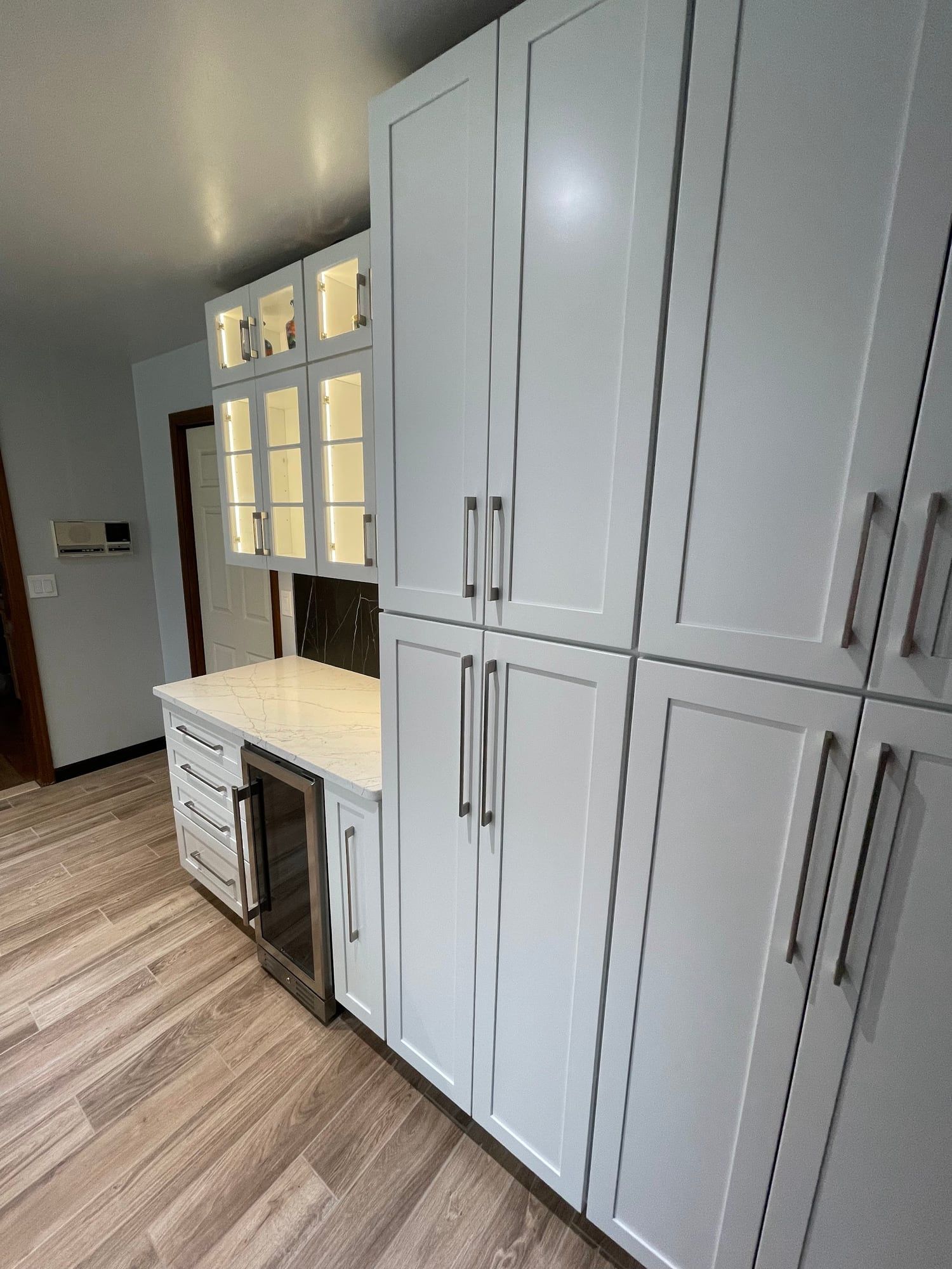 Floor-to-ceiling white pantry cabinets with long bar pulls