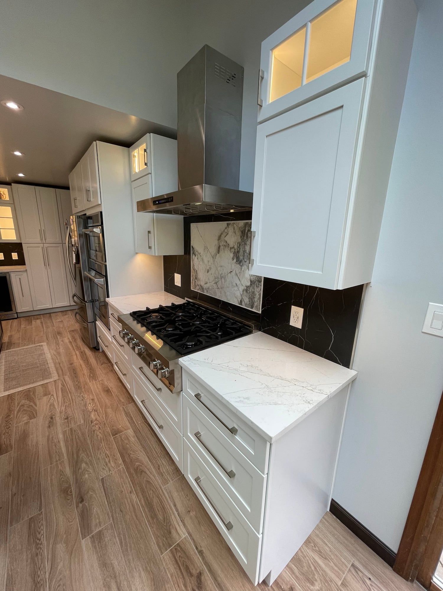 Run of white cabinetry from the range to the wall ovens