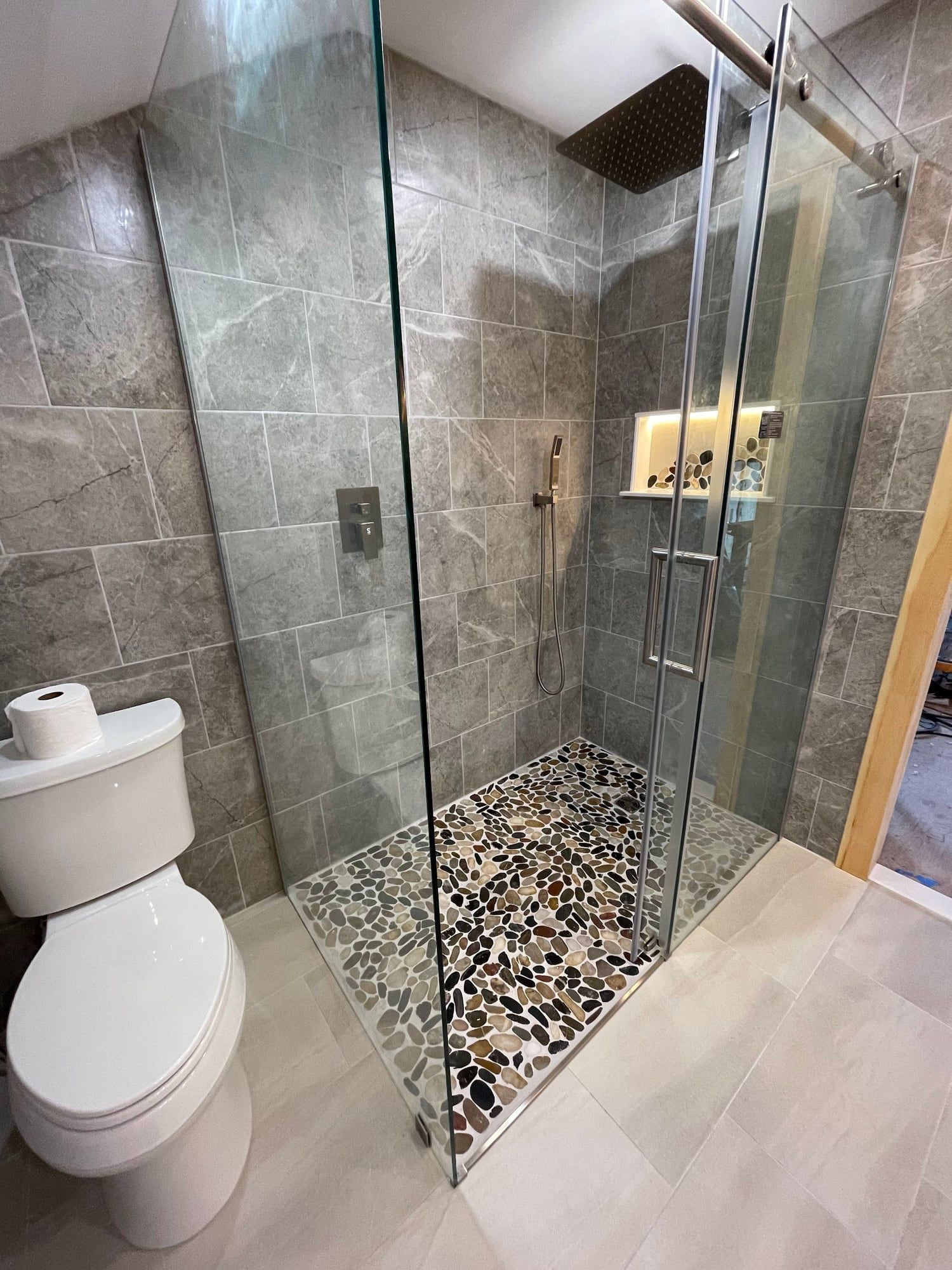 Shower glass, lit niche and pebble floor