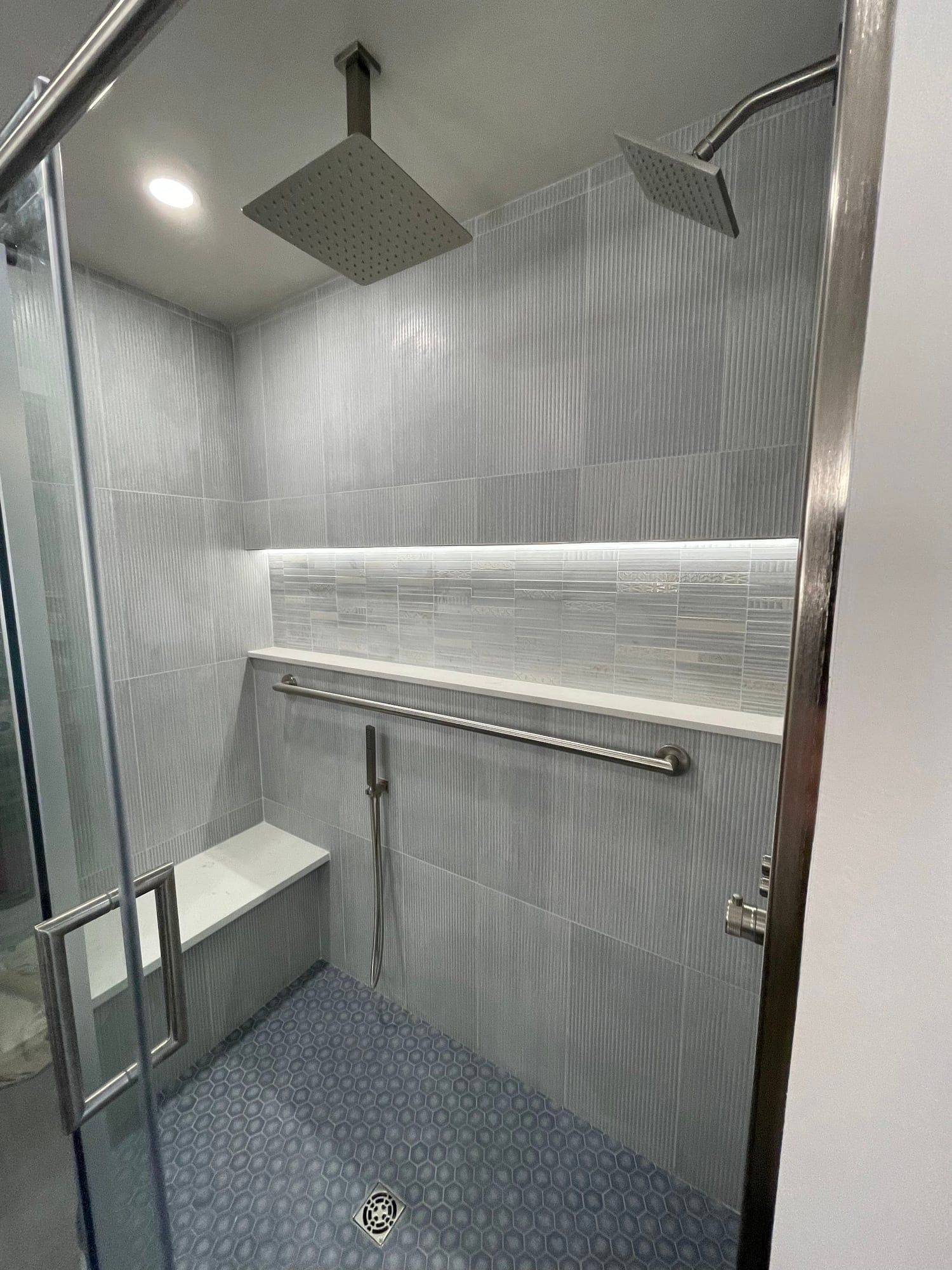 Shower with ceiling rain head, lit niche and tiled bench