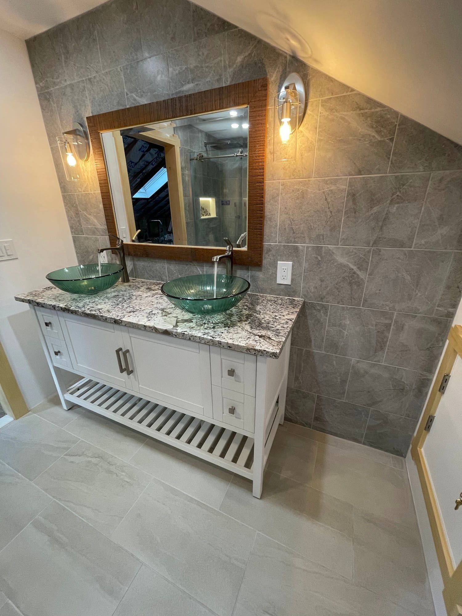Wood-framed mirror and sconces over vessel sinks