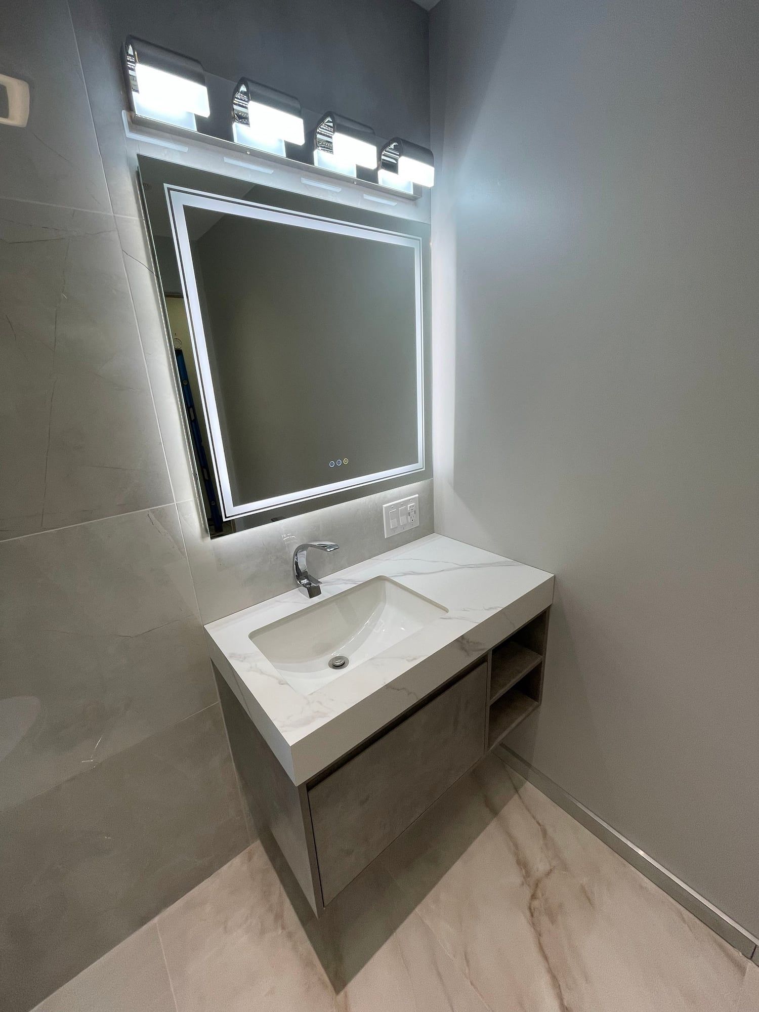Floating vanity under a backlit mirror