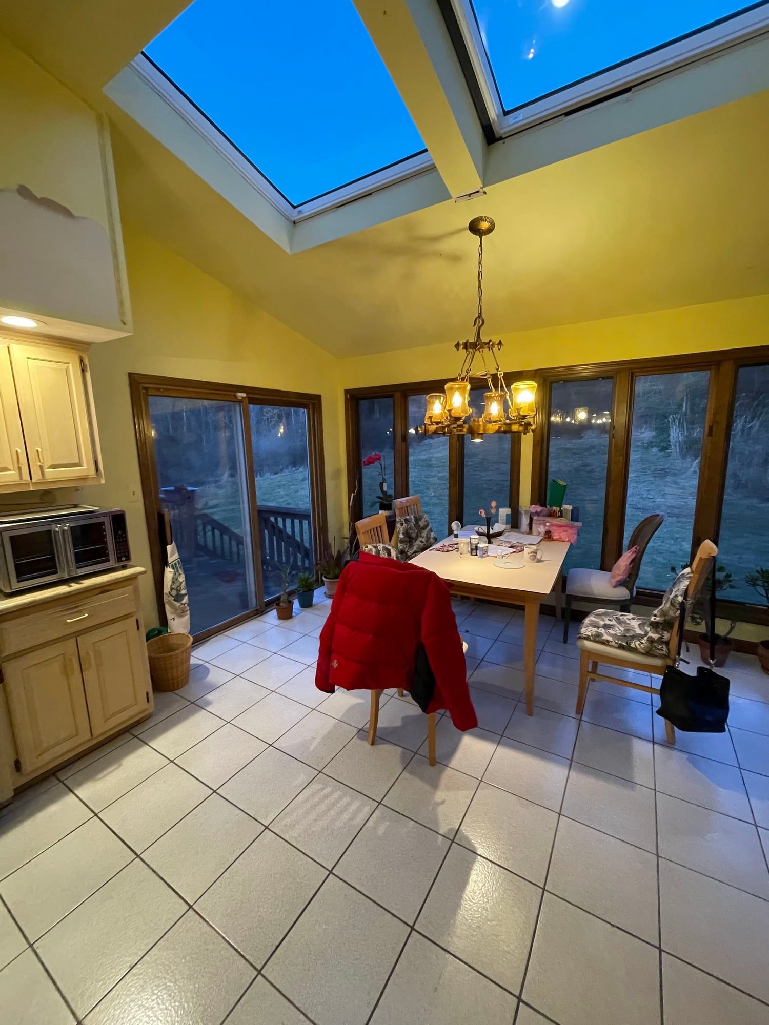 Before: yellow walls, worn tile and a dining table under the skylights