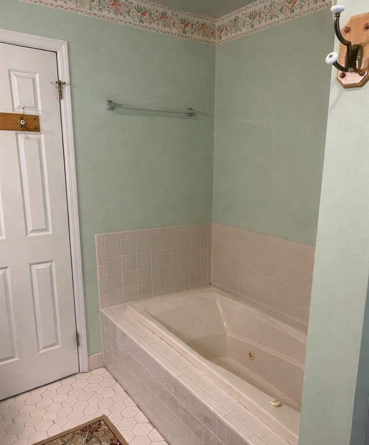 Before: a jetted tub in a corner of pink tile