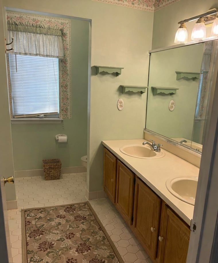 Before: oak double vanity with cultured-marble top and a wall mirror