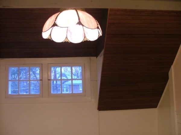 Sloped wood-plank ceiling above twin windows
