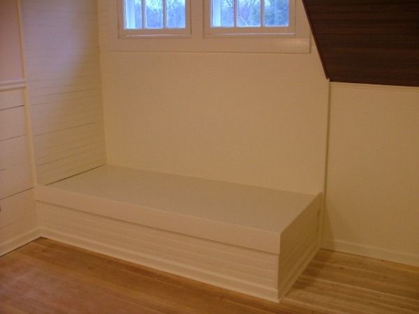 Built-in window seat under a sloped wood ceiling