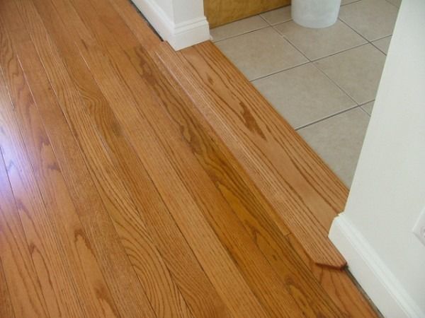Oak strip floor meeting tile at a clean threshold