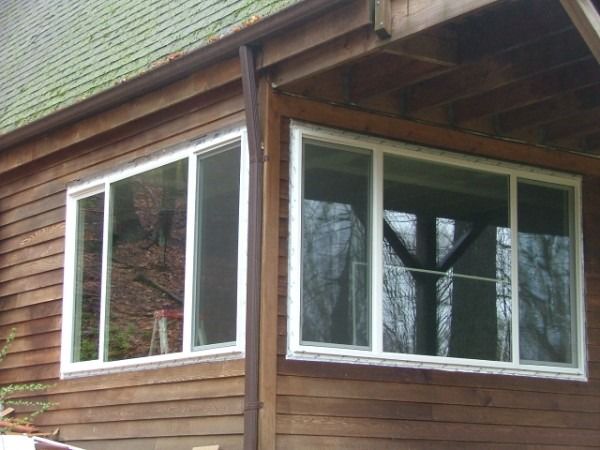 Corner of a wood-sided house with a new bank of windows